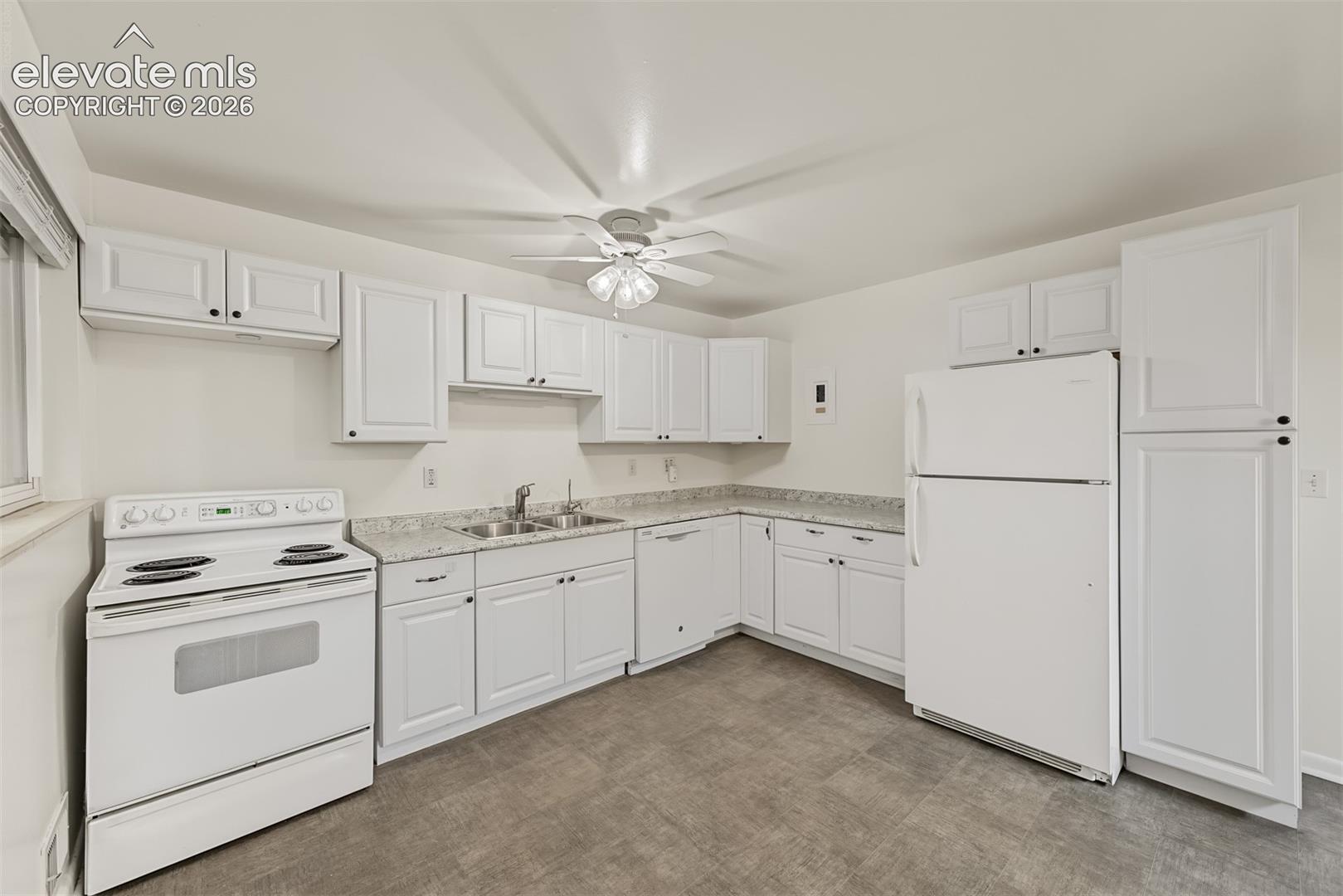 Kitchen featuring white cabinetry, stone-finish countertops, tile flooring, and a stainless steel double-basin sink