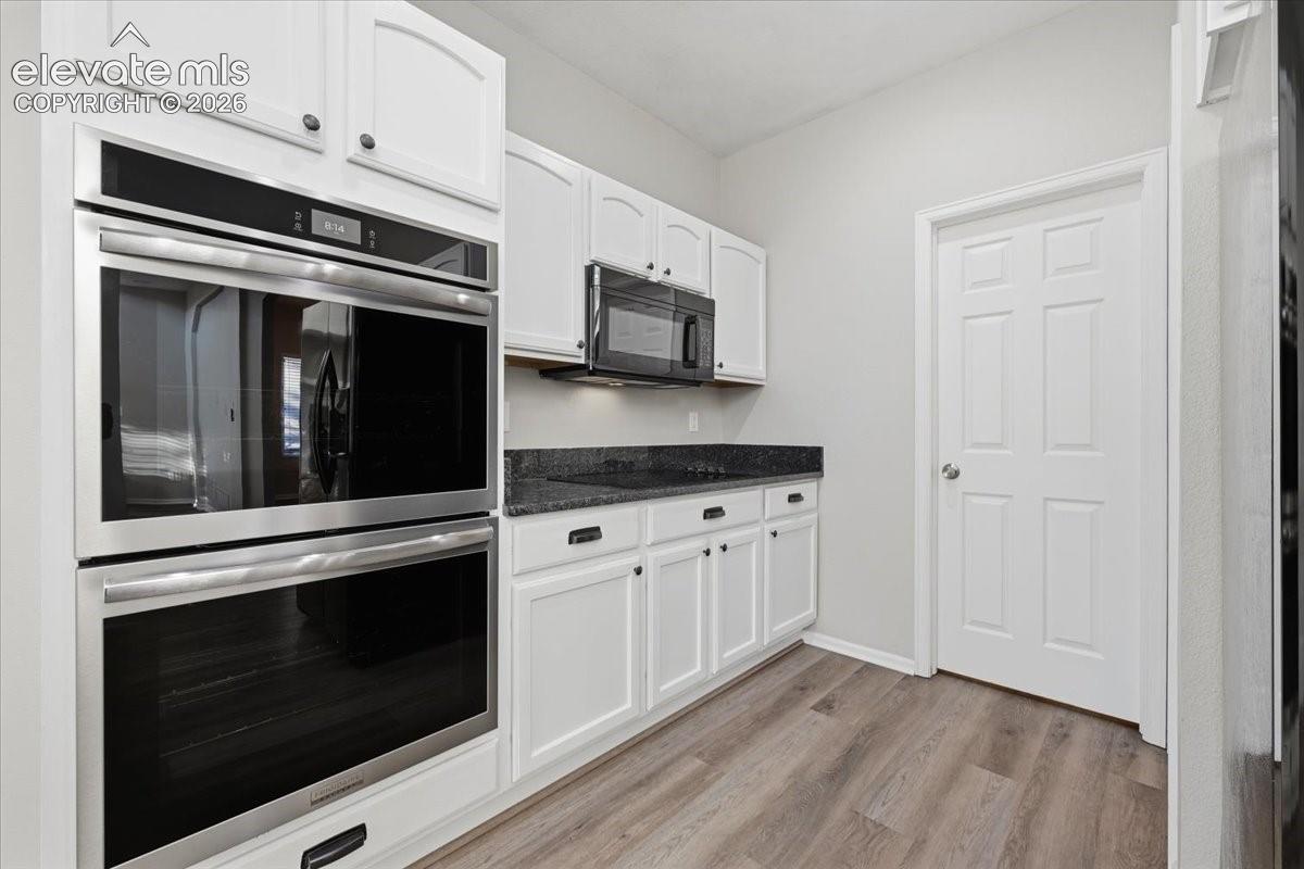 Spacious pantry and half bath are tucked back in the kitchen 