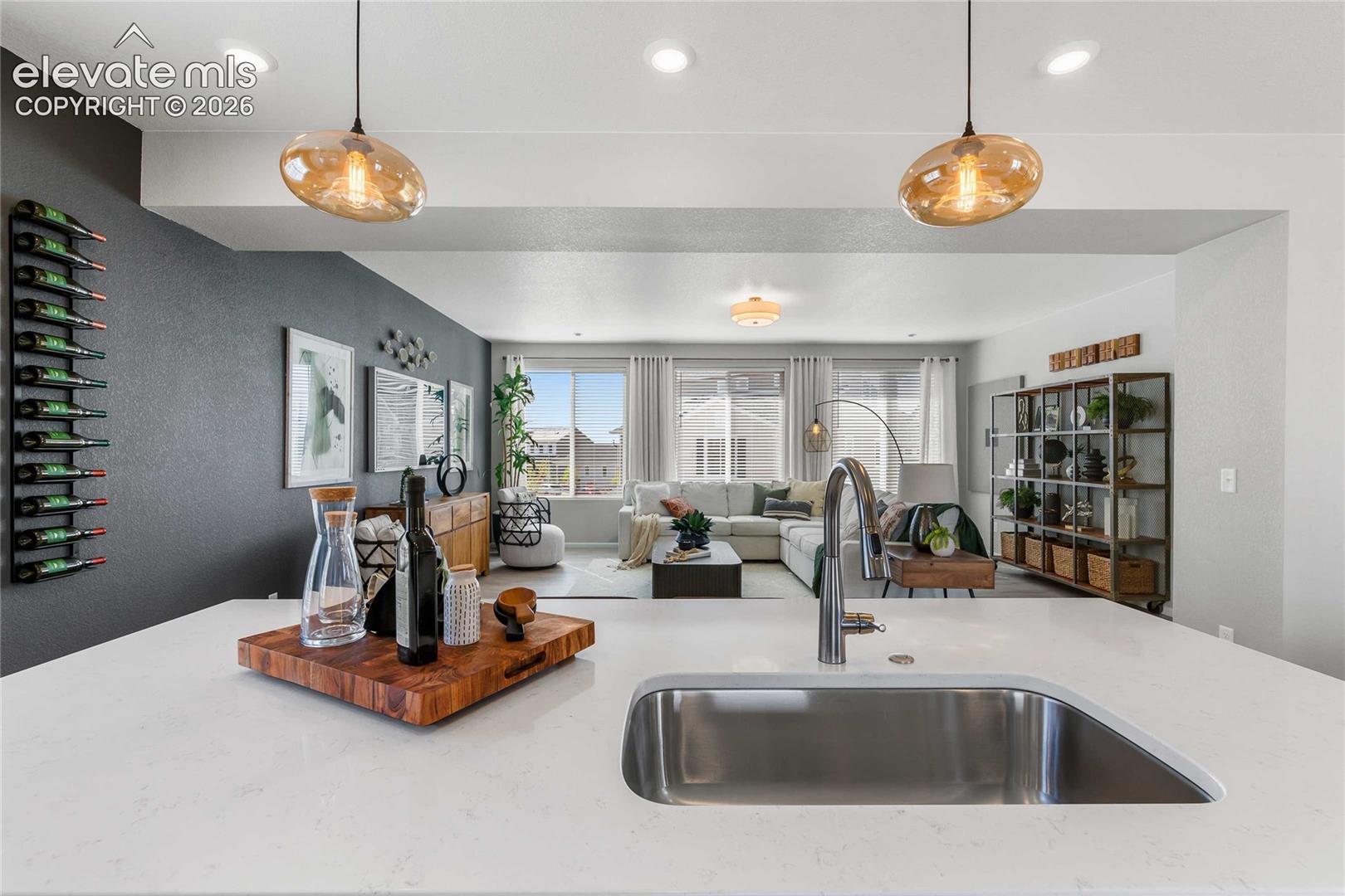 Kitchen island with a stainless steel undermount sink, gooseneck faucet, and white countertop
*photos of a model home*
