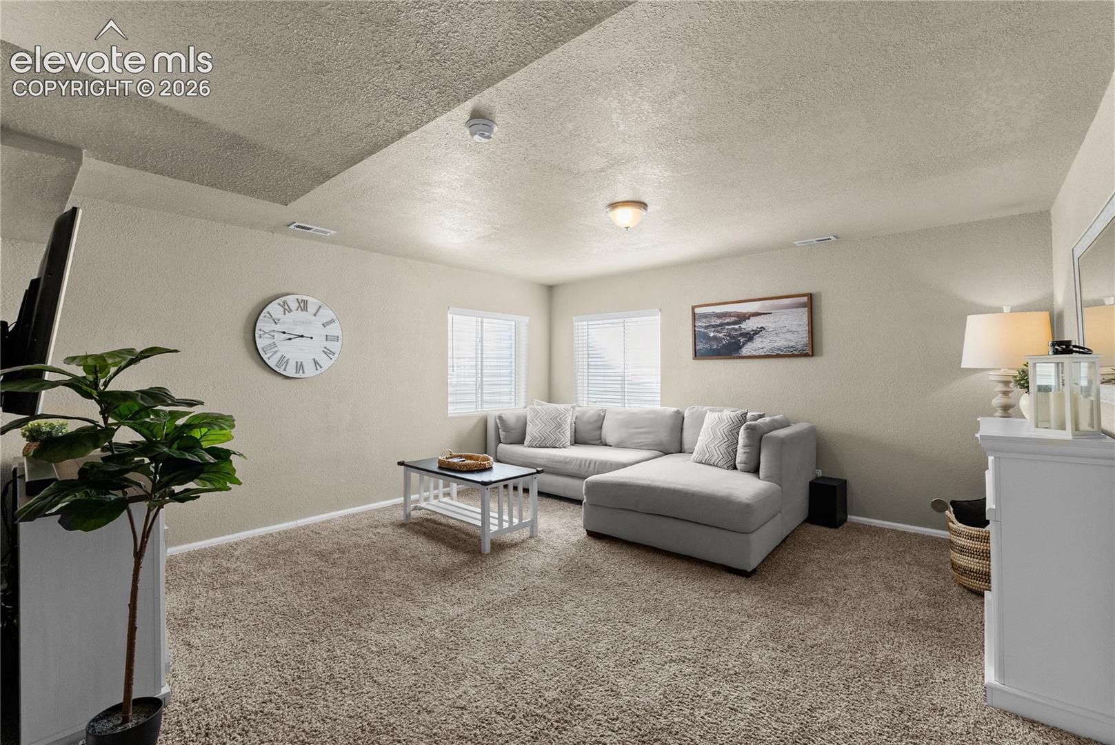 Carpeted flooring throughout, recessed lighting, and windows with blinds