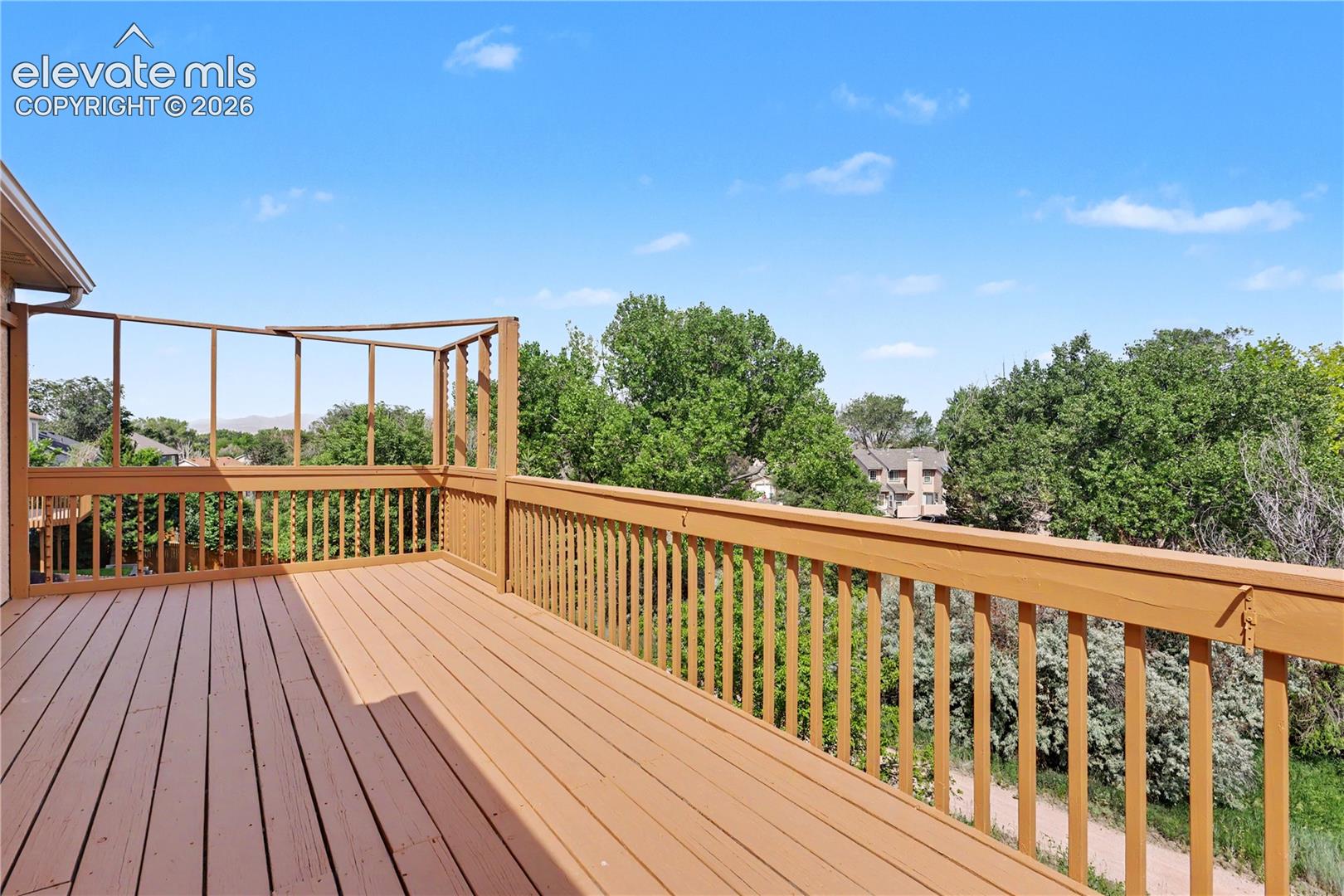 Spacious outdoor deck featuring wooden decking and railing. Virws of Pikes Peak in person - the photo doesn't do it justice!