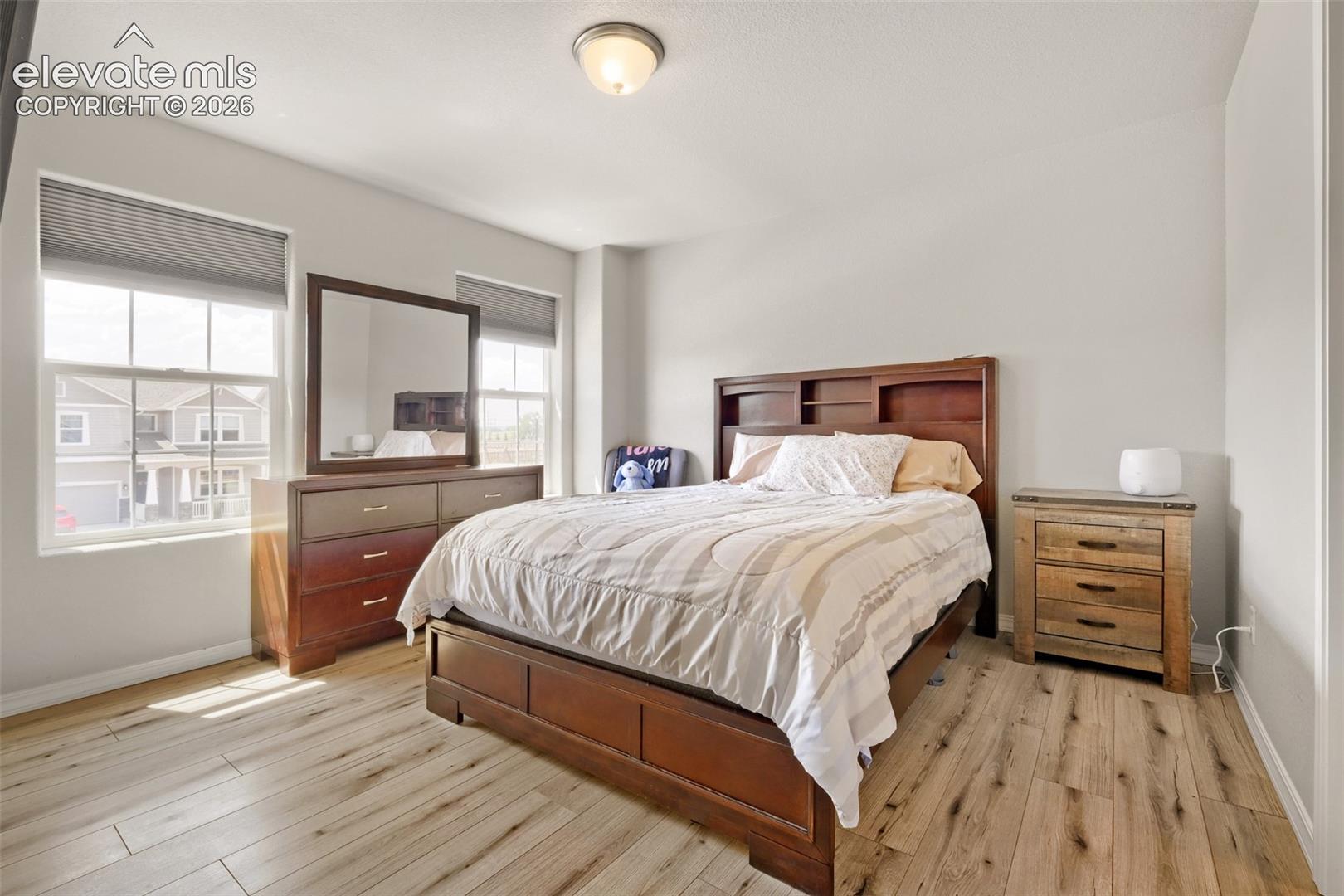 Bright interior space featuring light wood-finish flooring, neutral wall tones, and multiple windows