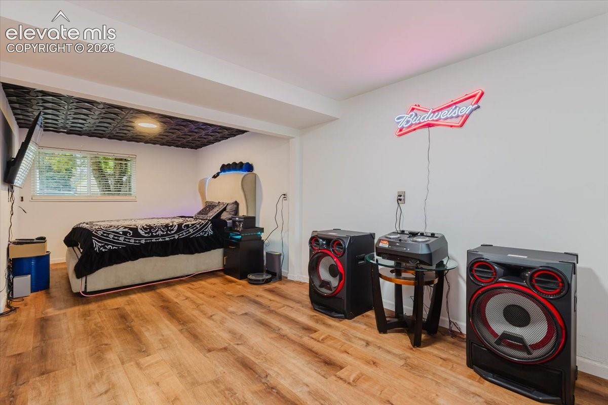 Spacious room featuring wood-finish flooring and a white wall finish