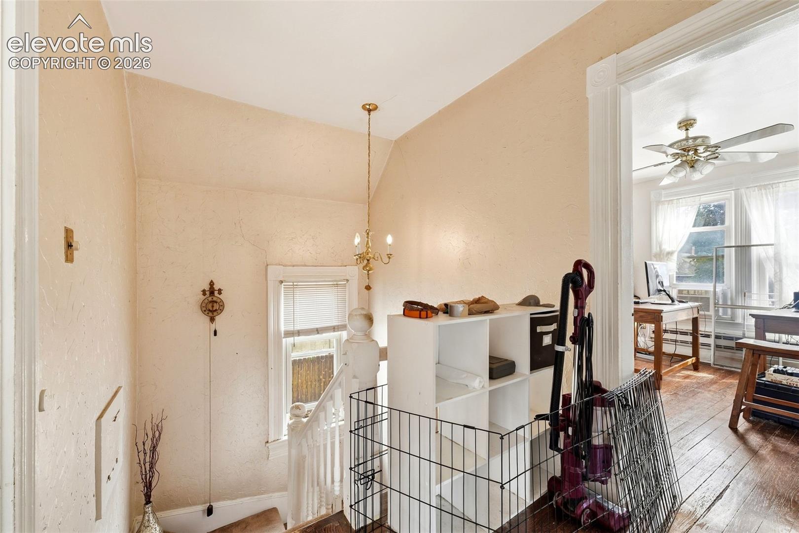Hardwood flooring and decorative ceiling fan in the adjacent room