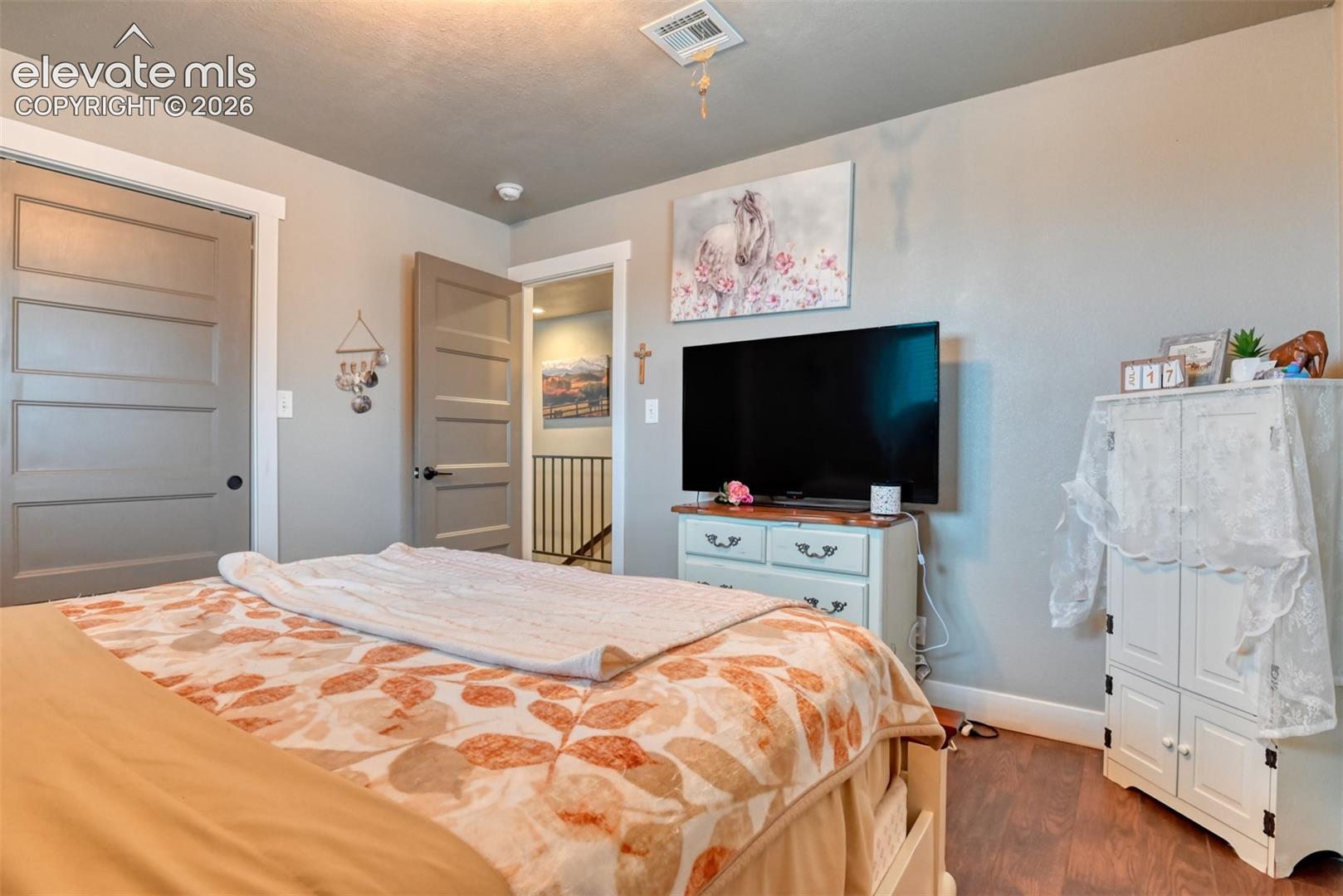 Bedroom with a closet and dark wood finished floors