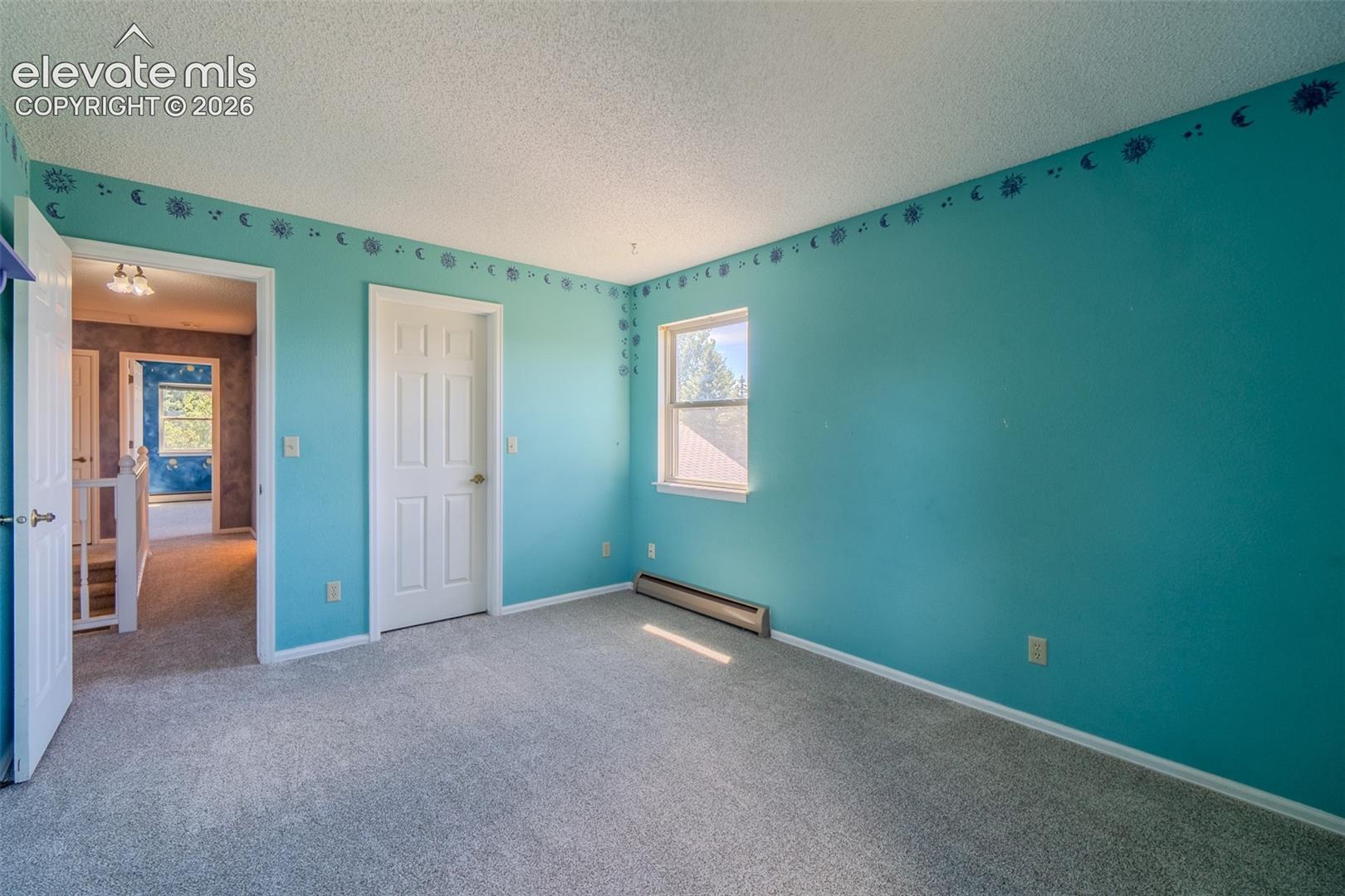 Three of Four bedrooms upstairs, new Carpet featuring a white interior door, a single window, and a baseboard heating unit