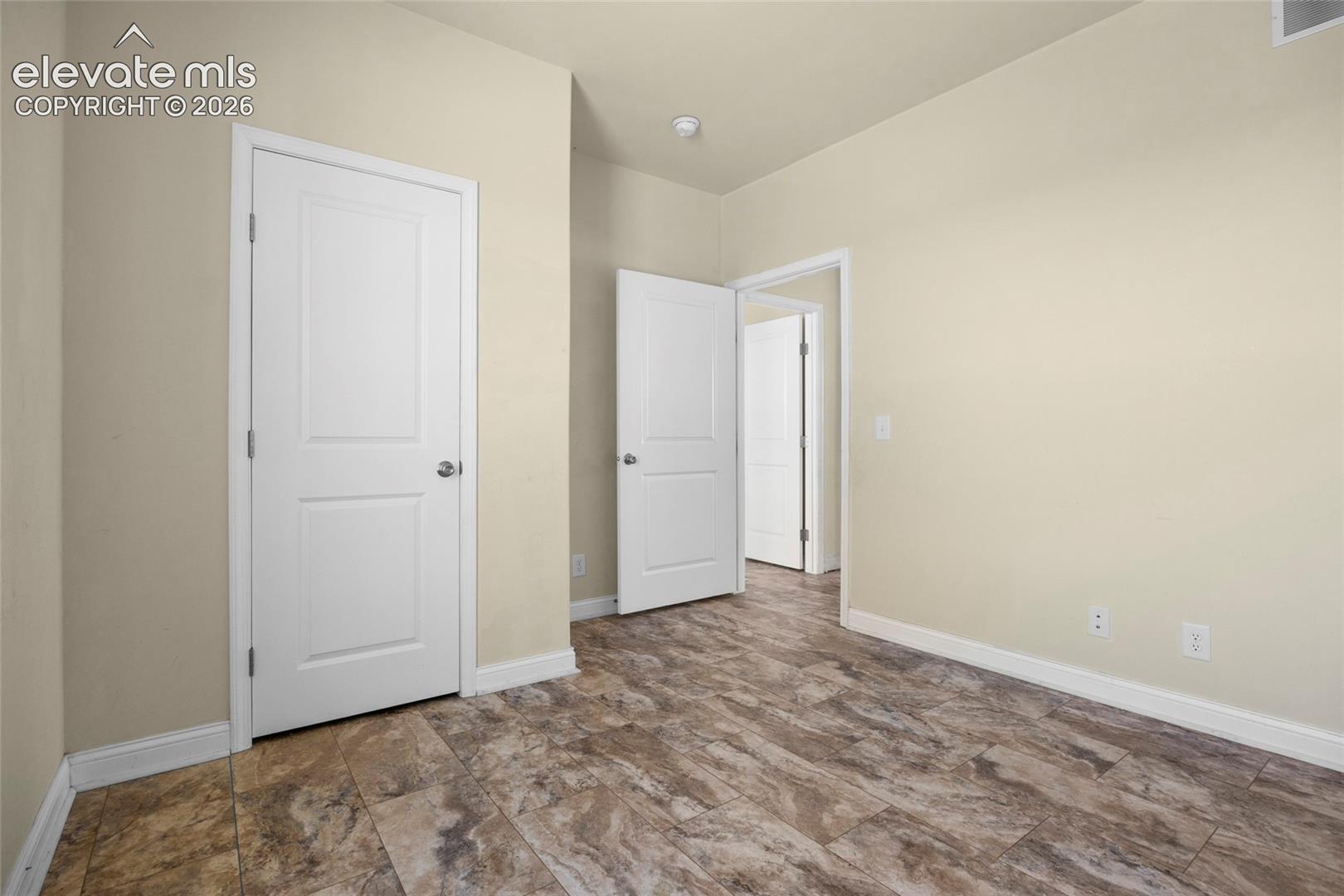 Neutral-toned interior space featuring wood-finish tile flooring, two-panel interior doors, and recessed ceiling lighting