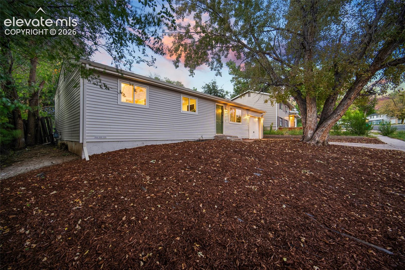Siding exterior, established tree, and a mulched front yard