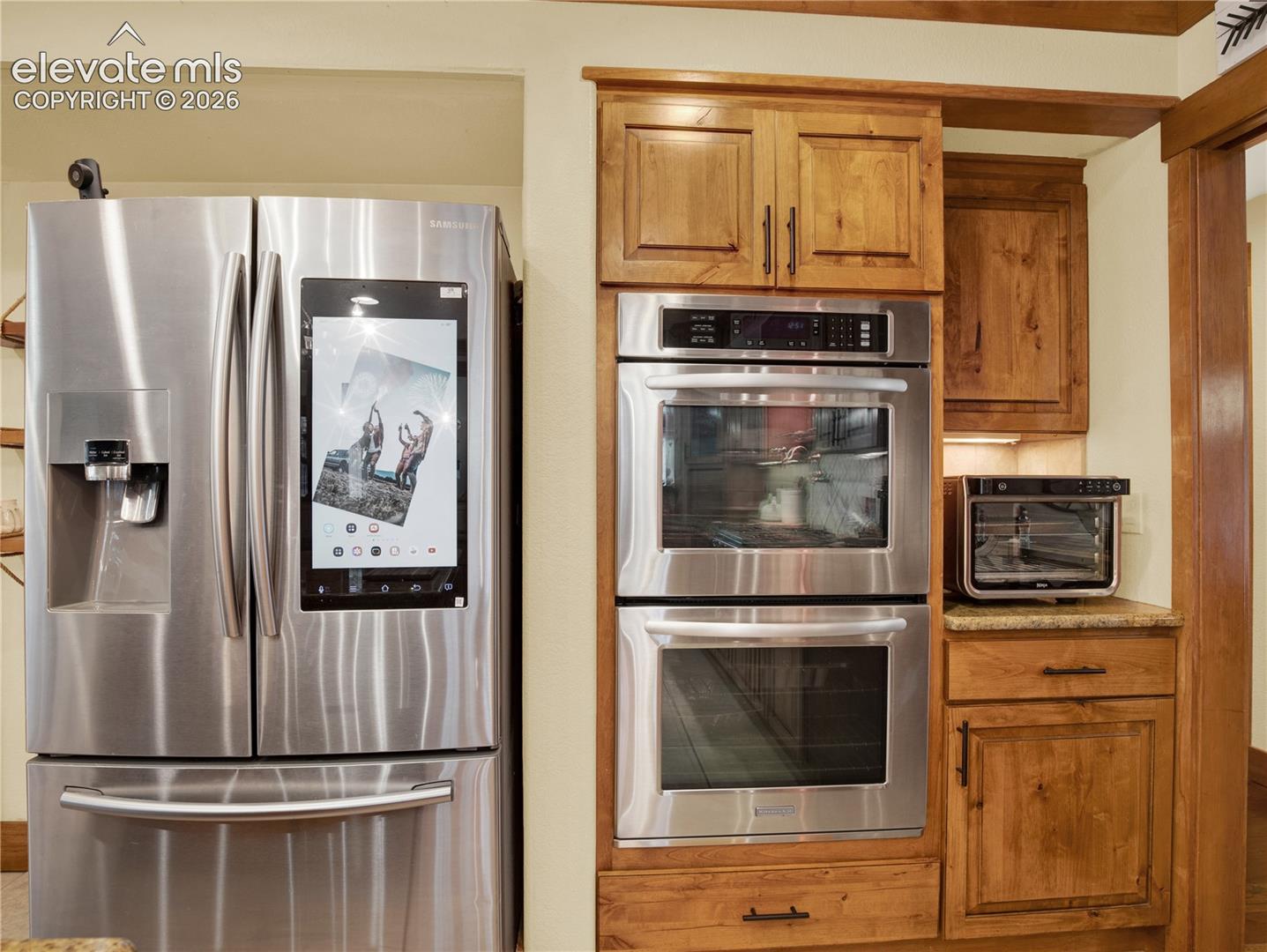 Kitchen Aid double oven aside a smart Samsung refrigerator