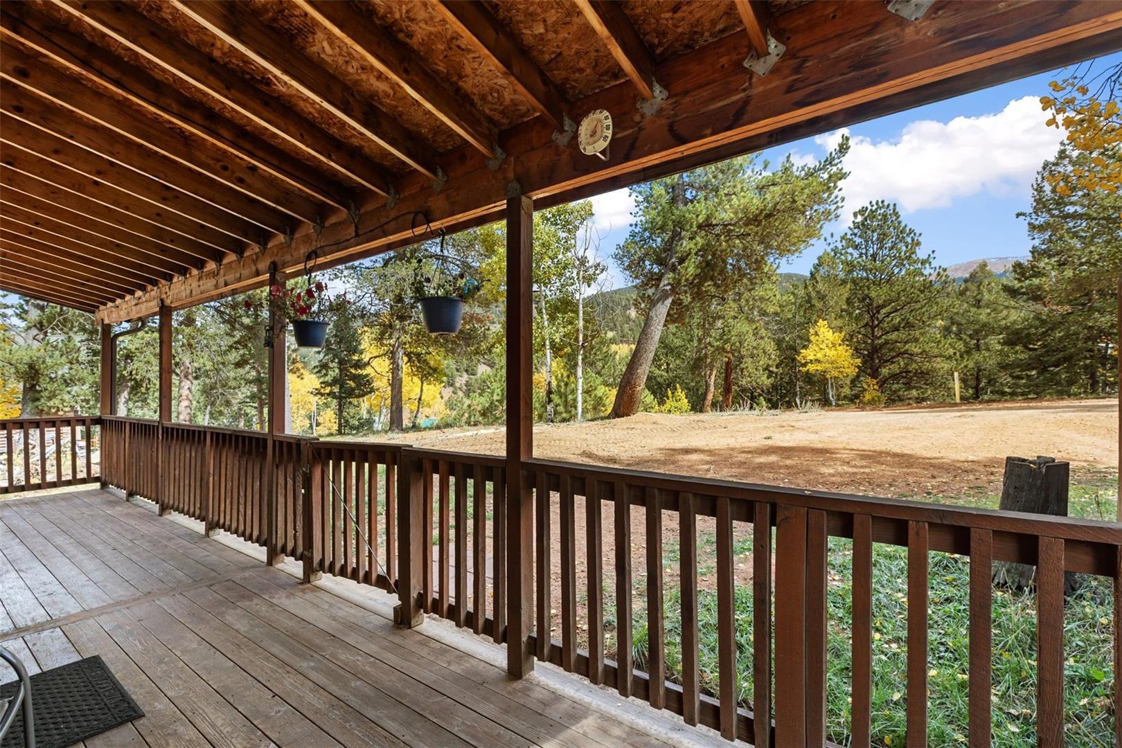 Expansive outdoor deck featuring wood flooring, wood railing, and a wood slat ceiling