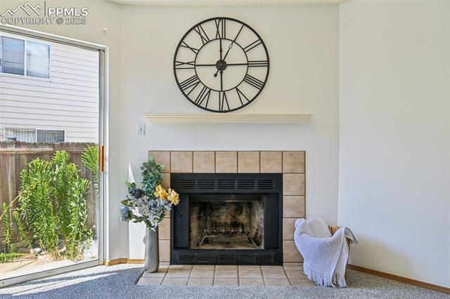 Detailed view of a tiled fireplace and carpet flooring