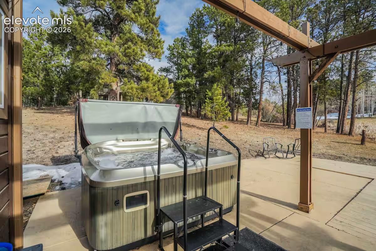 Outdoor spa with integrated steps, situated on a concrete patio