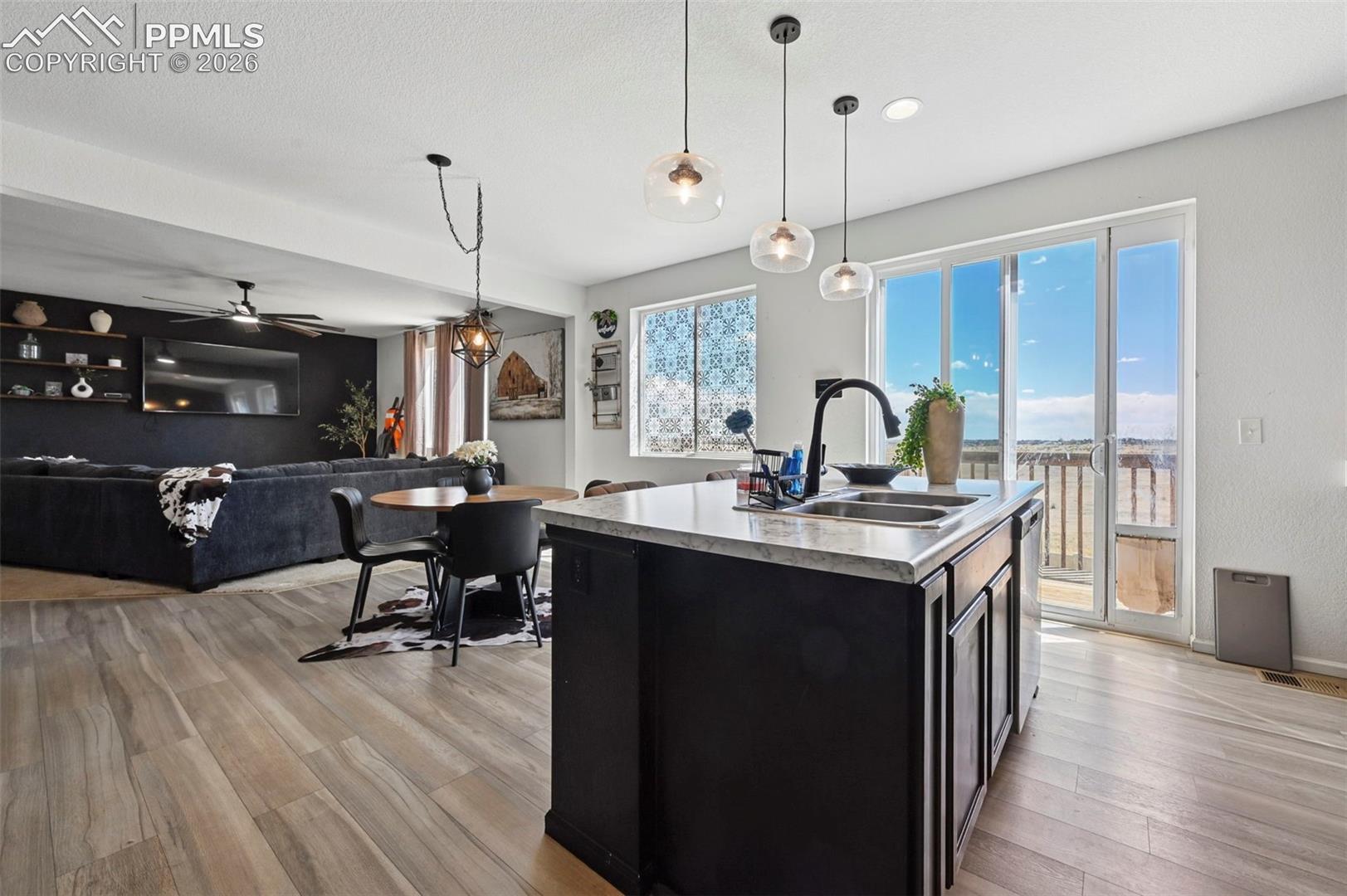 Kitchen island featuring a double-basin sink and quartz countertop