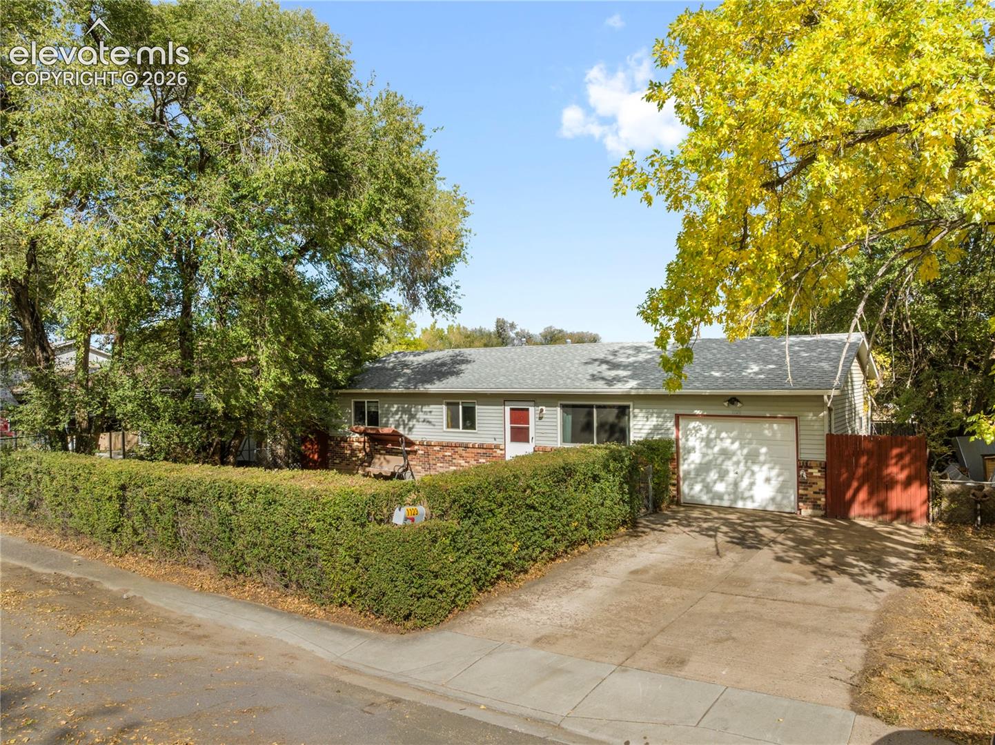 Fully fenced in front yard with hedges for privacy