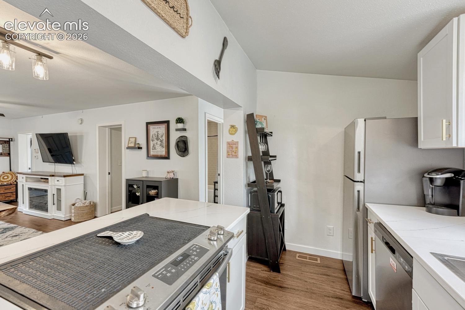 Modern kitchen featuring white quartz countertops, cabinetry, stainless steel appliances, white quartz countertops,