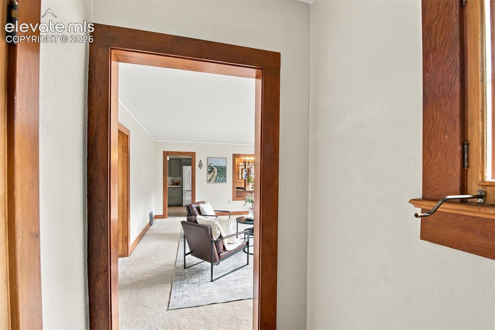 Small foyer with coat closet and view into the living room