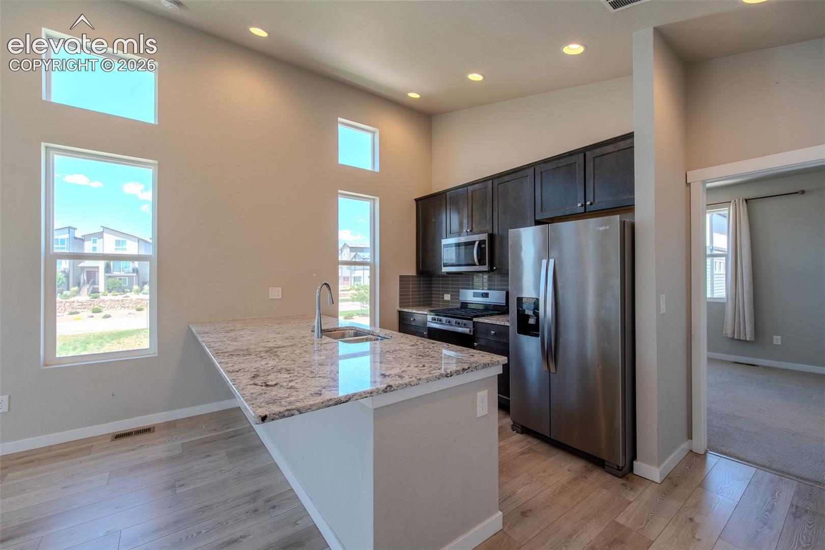 Beautiful Kitchen with granite breakfast bar, espresso cabinets, and stainless steel appliances.
