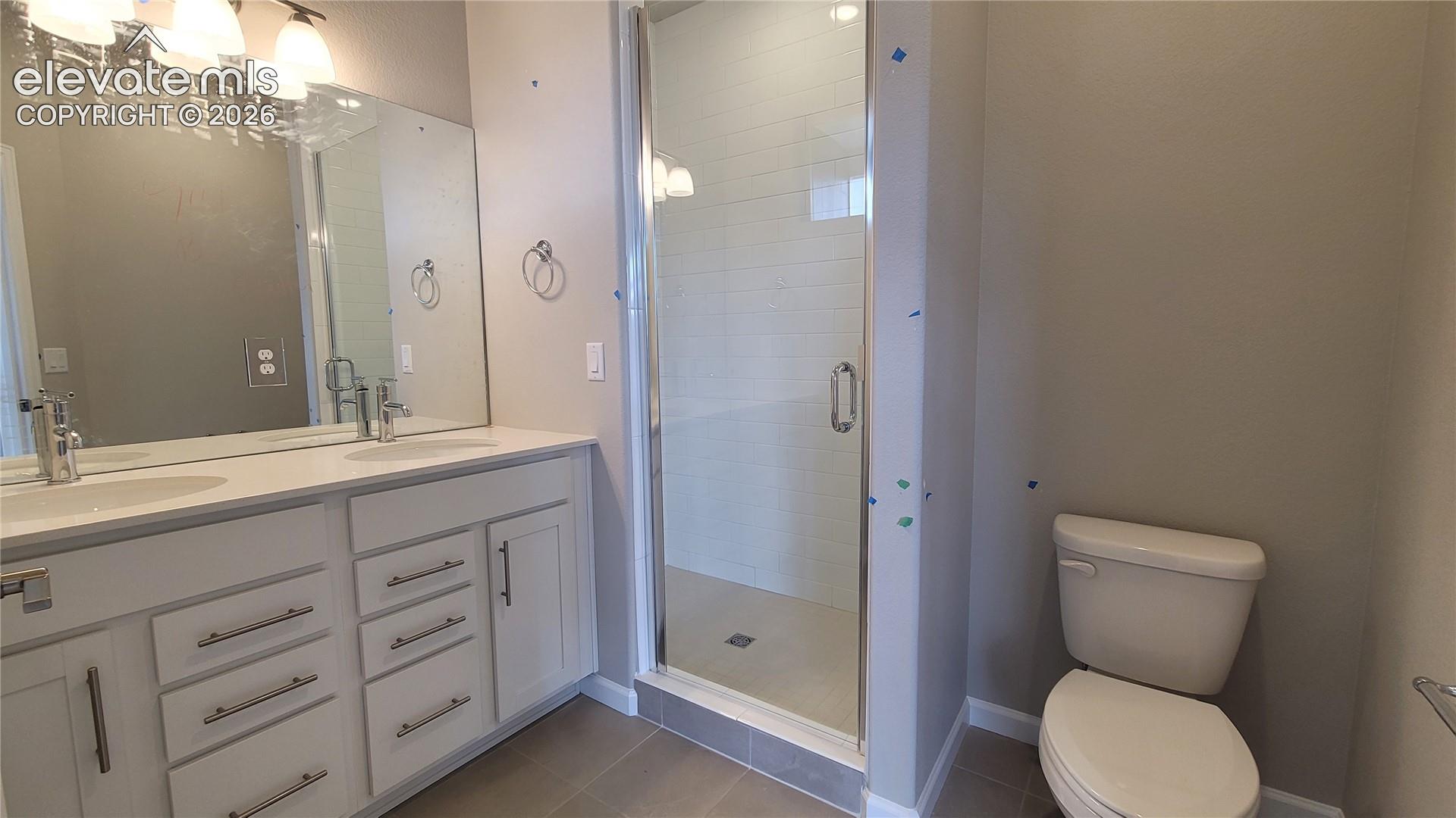 Primary Bathroom with quartz countertop, double vanities, and tile surrounds! 
