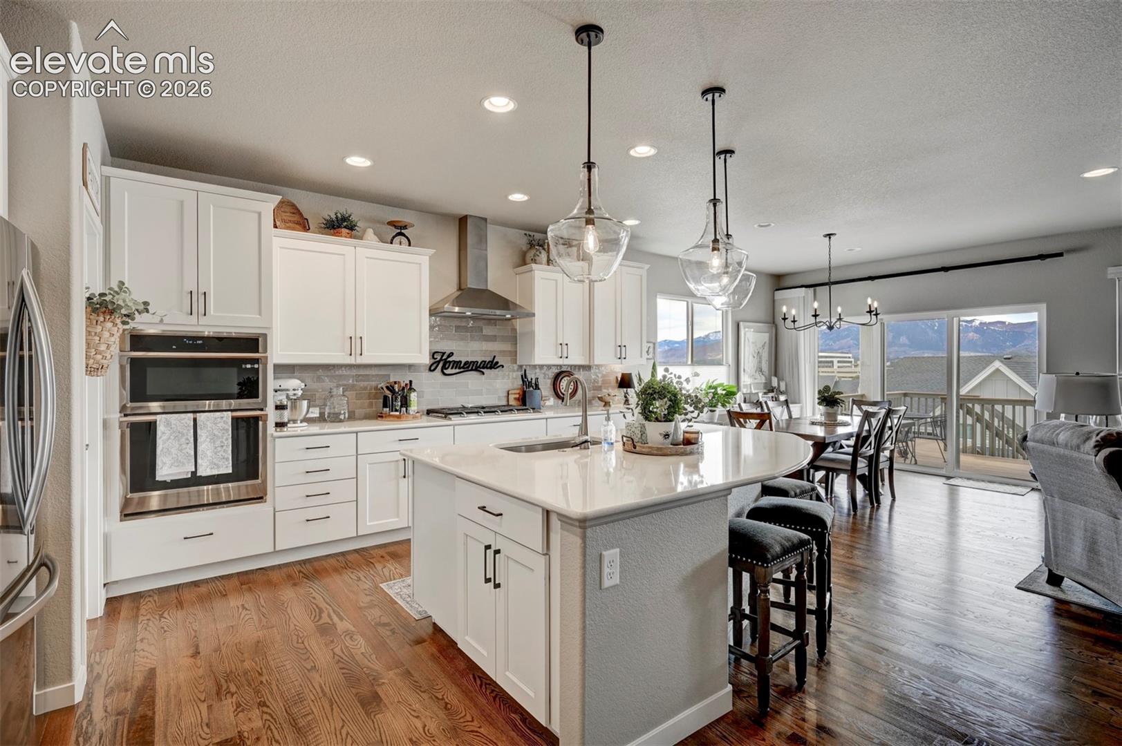 Gourmet kitchen featuring white cabinetry, stainless steel appliances, and a central island with a breakfast bar