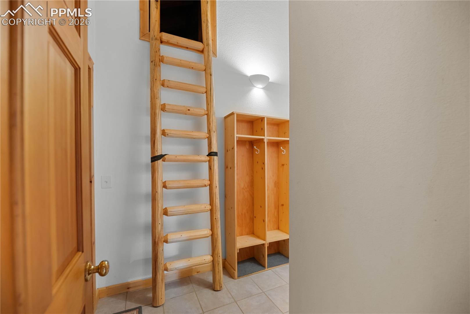 Mudroom with light tile patterned flooring