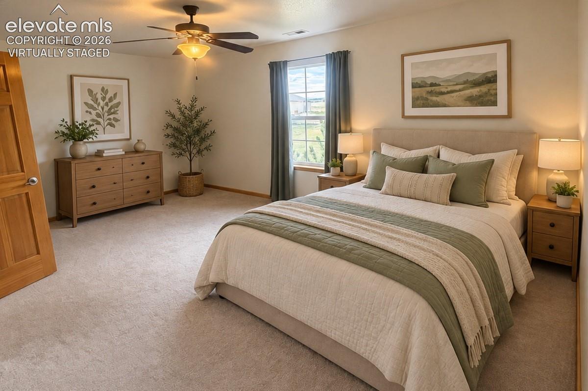 Upstairs bedroom 3/3.Lg walk-in closet. Carpeted room featuring a ceiling fan with integrated lighting, a window with drapery, and a wood-finish door. Virtually staged.