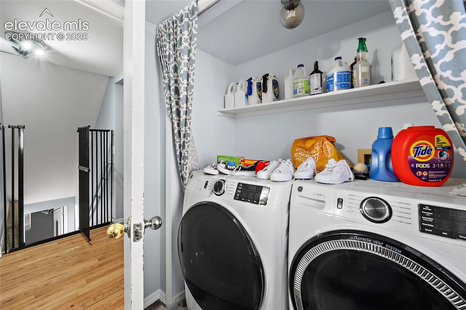 Dedicated laundry area featuring a built-in shelving unit, white walls, and a light fixture