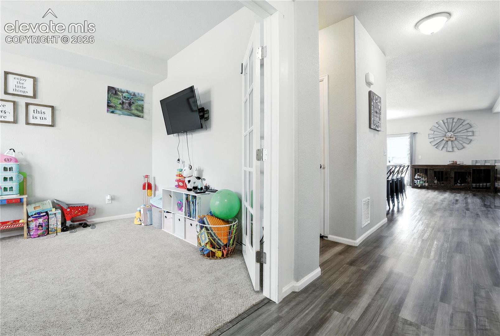 Neutral-toned carpeting, wood-finish flooring, and a semi-flush ceiling light fixture