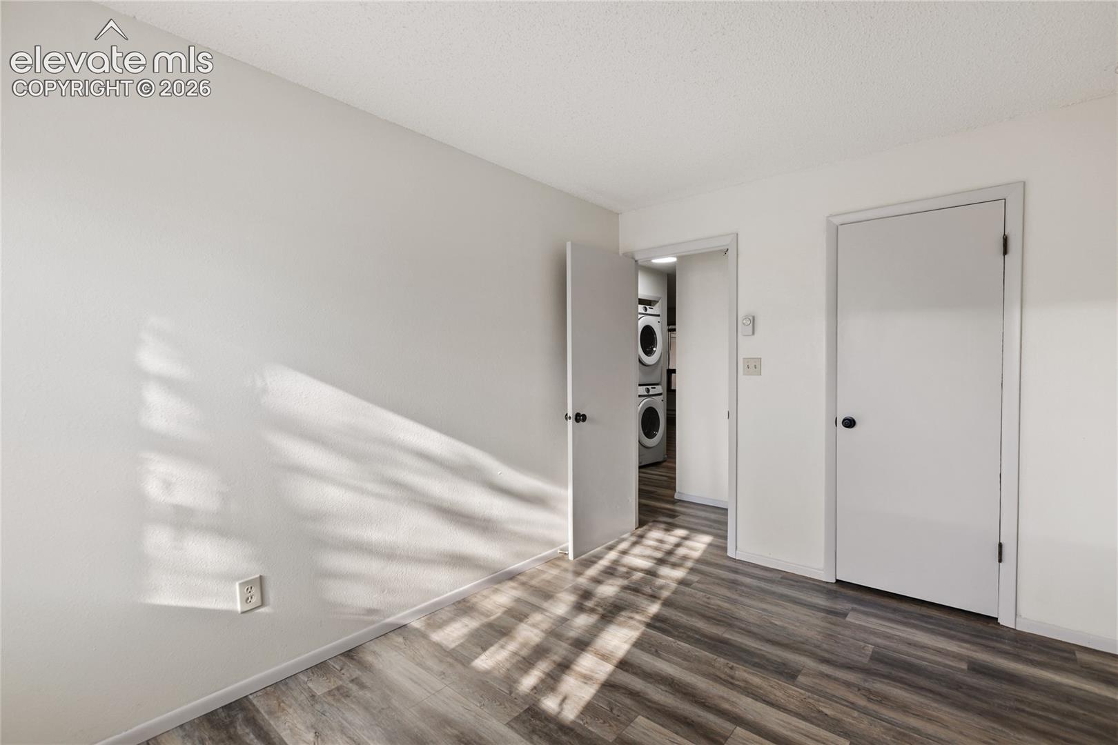 Interior space featuring wood-finish flooring, white walls, and white trim