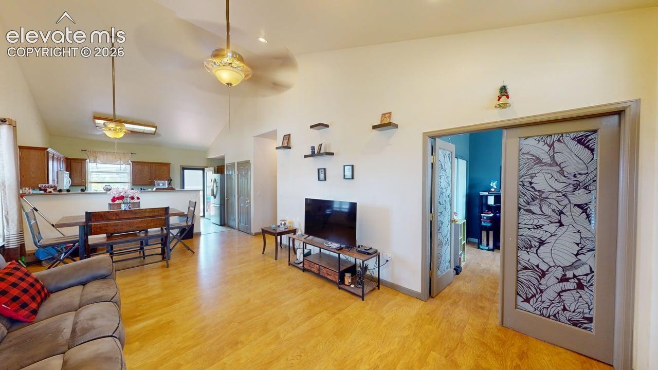 Open-concept living area with vaulted ceilings and wood-finish flooring