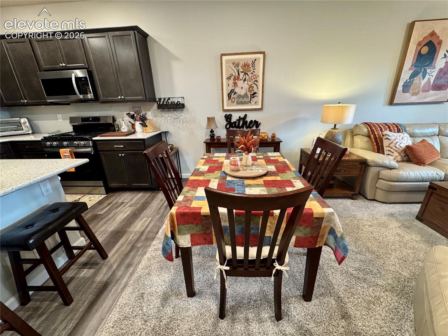 Kitchen featuring dark cabinetry, stone-surface countertops, and wood-finish flooring