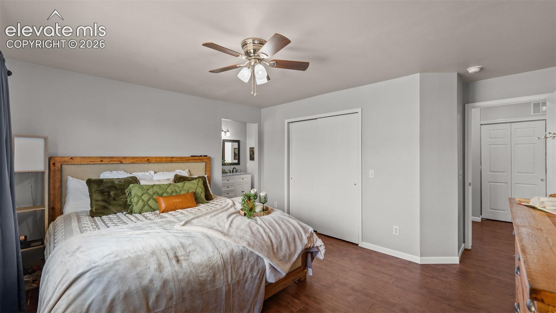 Wood-finish flooring, ceiling fan with integrated lighting, and multiple closet doors