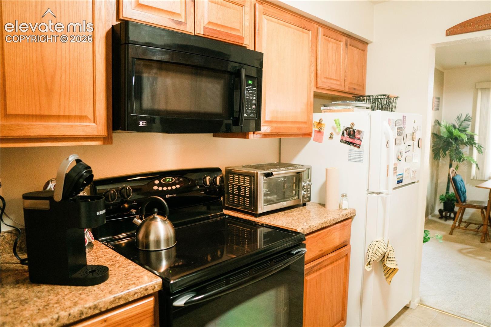 Wood-finish cabinetry paired with a black over-the-range microwave