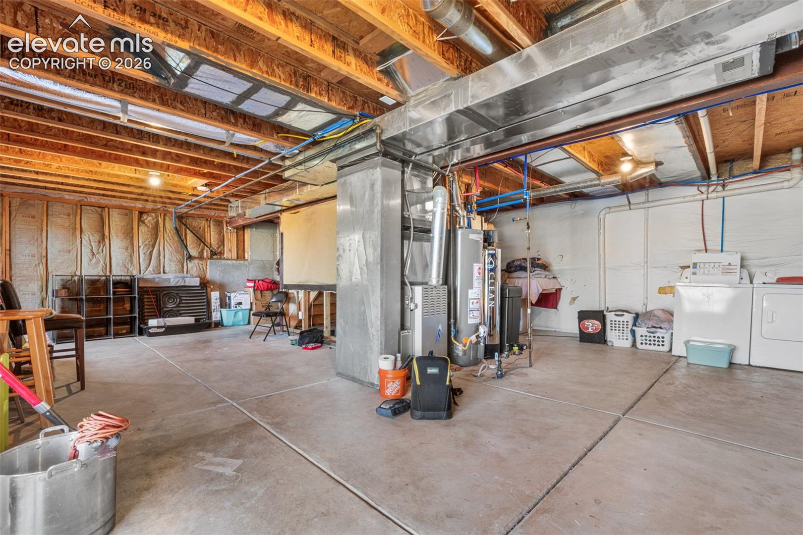 Unfinished utility space featuring exposed wood-joist ceiling, concrete flooring, dedicated laundry hookups, and integrated HVAC system