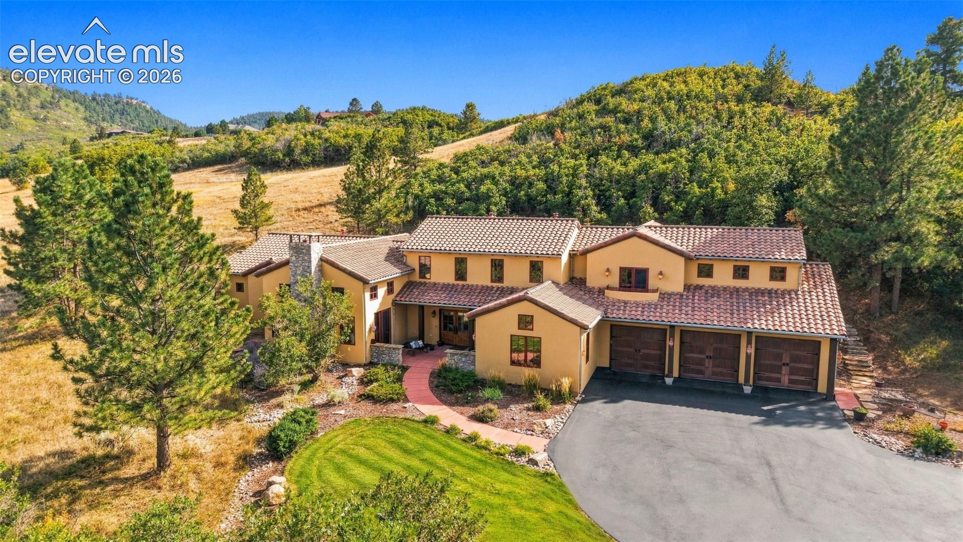 Mediterranean-style residence featuring stucco exterior, a tiled roof, and a three-car garage