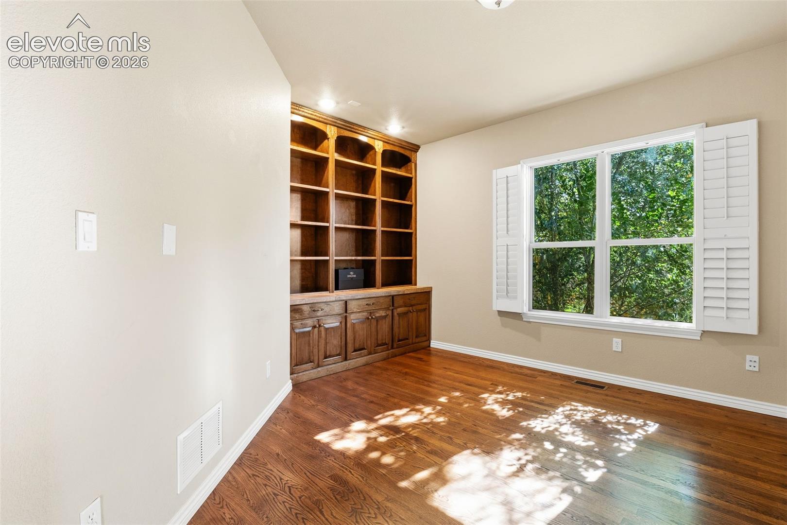 OFFICE WITH BUILT-IN SHELVES AND PLANTATION SHUTTERS