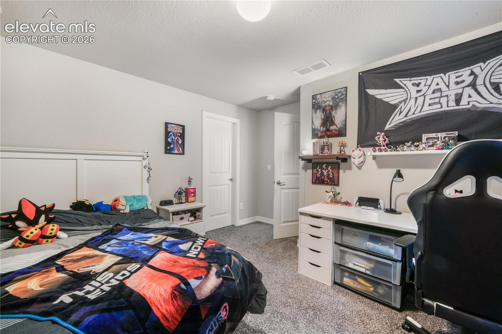 White paneled door with smart lock, overhead cabinetry with light wood accent, and dark flooring