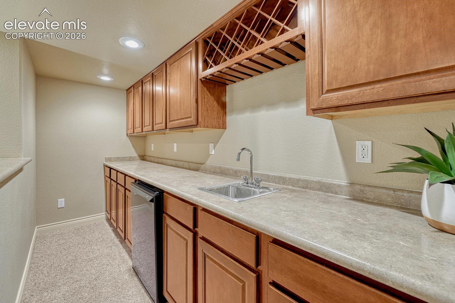 Basement wet bar with refrigerator & built-in wine rack to serve your favorite drinks and snacks.