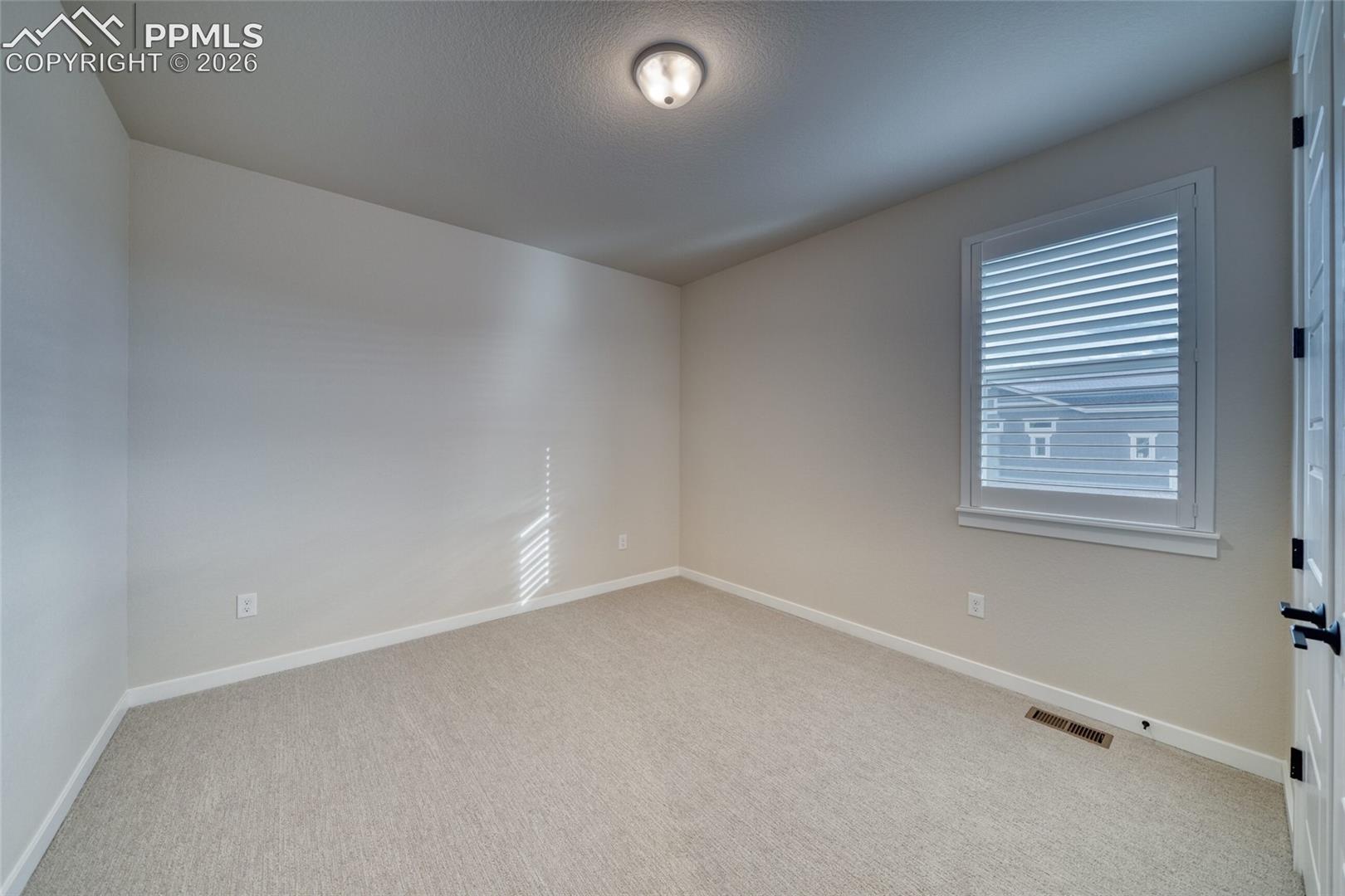 Unfurnished room with baseboards and light carpet