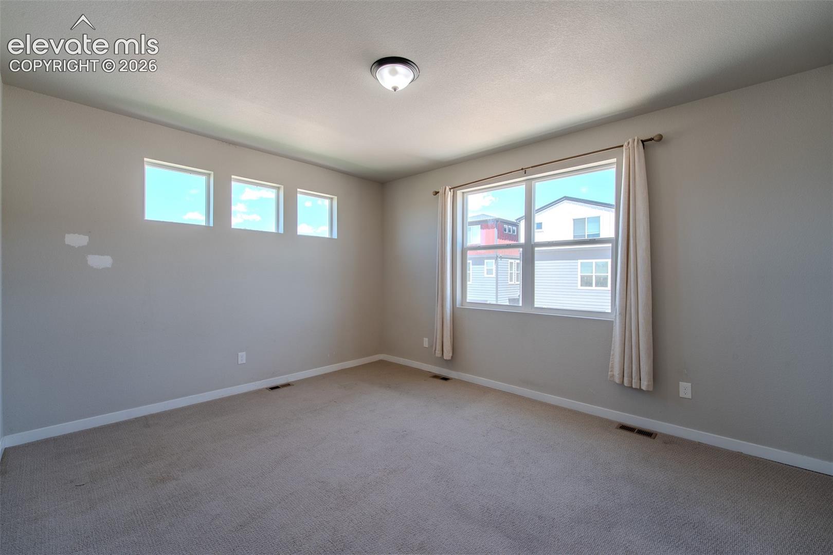 Upper Level Primary Bedroom with neutral carpet.
