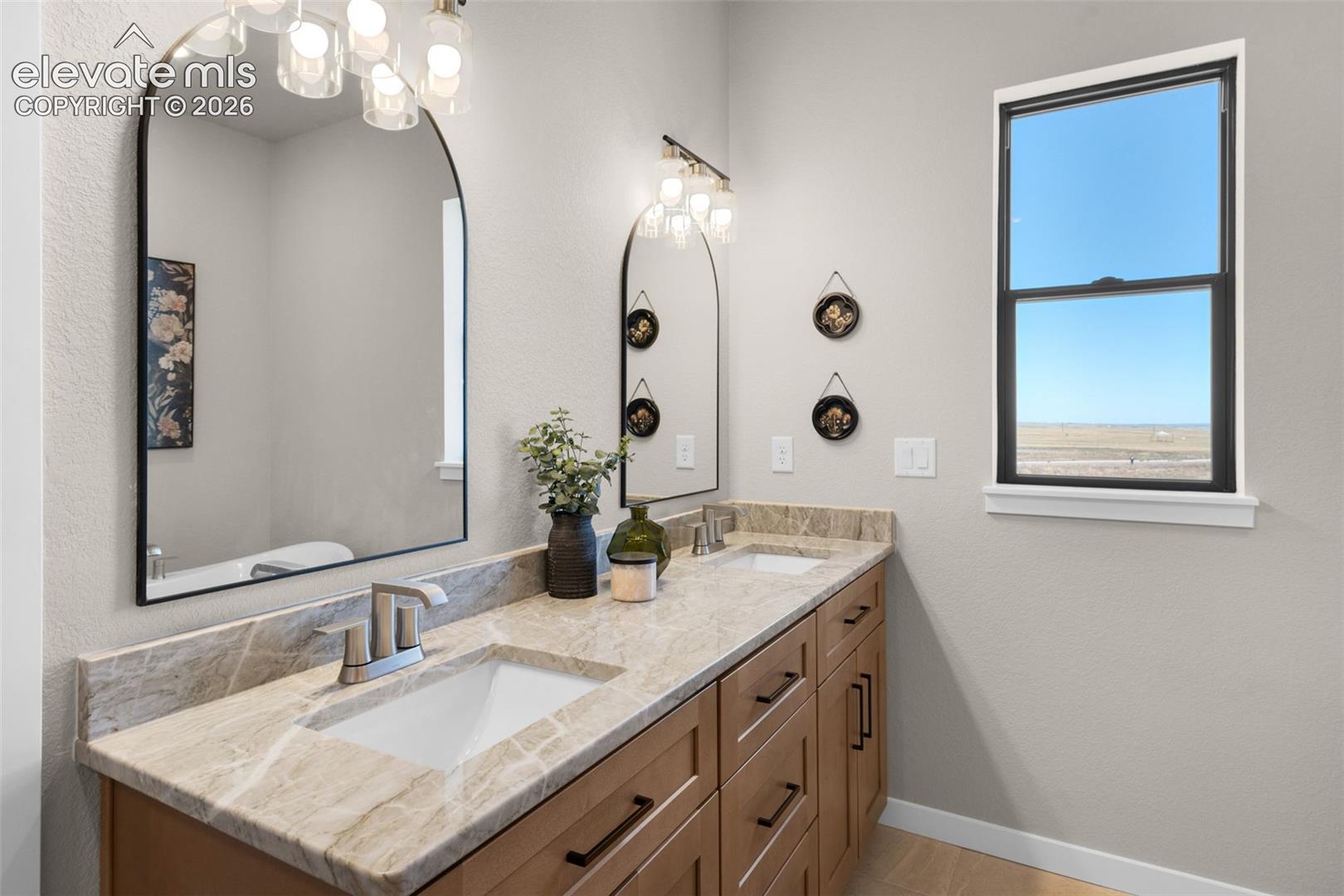Dual vanity with undermount sinks, light-toned countertop, and wood-finish cabinetry