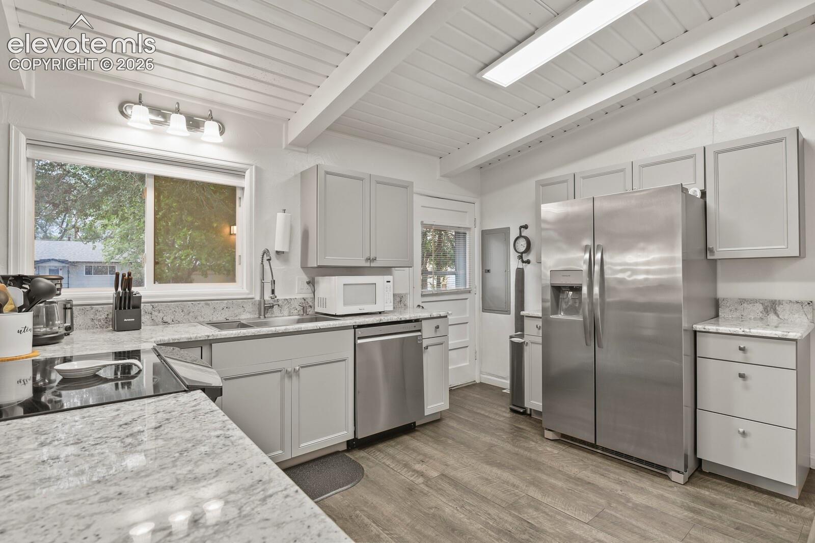 Kitchen from corner of breakfast bar looking towards door to the patio and backyard.