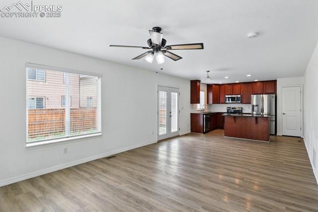 Kitchen with stainless steel appliances, a sink, open floor plan, dark countertops, and recessed lighting