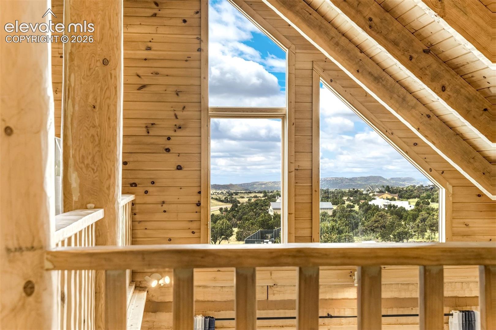 Vaulted wood-finish ceilings and exposed beams complement the wood-paneled walls