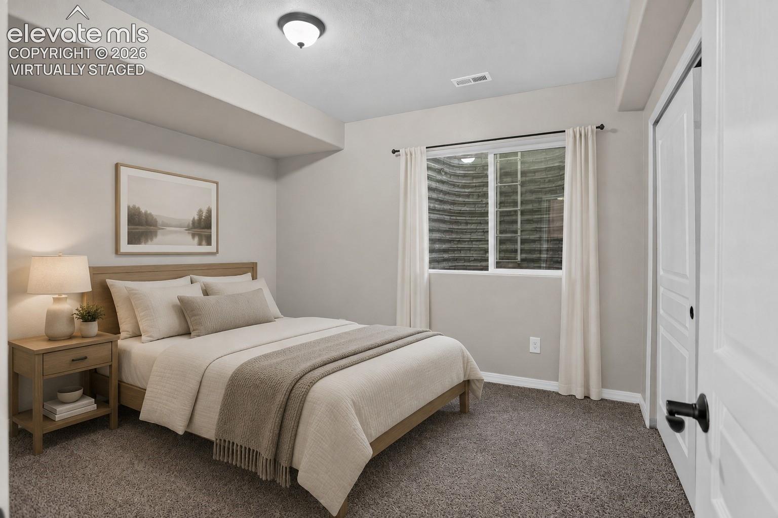 Virtually Staged - Window with white trim, gray carpet, and a white paneled door with black hardware