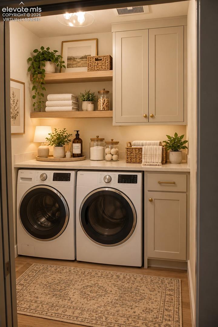 Virtually staged Laundry area featuring a side-by-side washer and dryer, shaker-style cabinetry, floating wood-finish shelving, and a built-in countertop