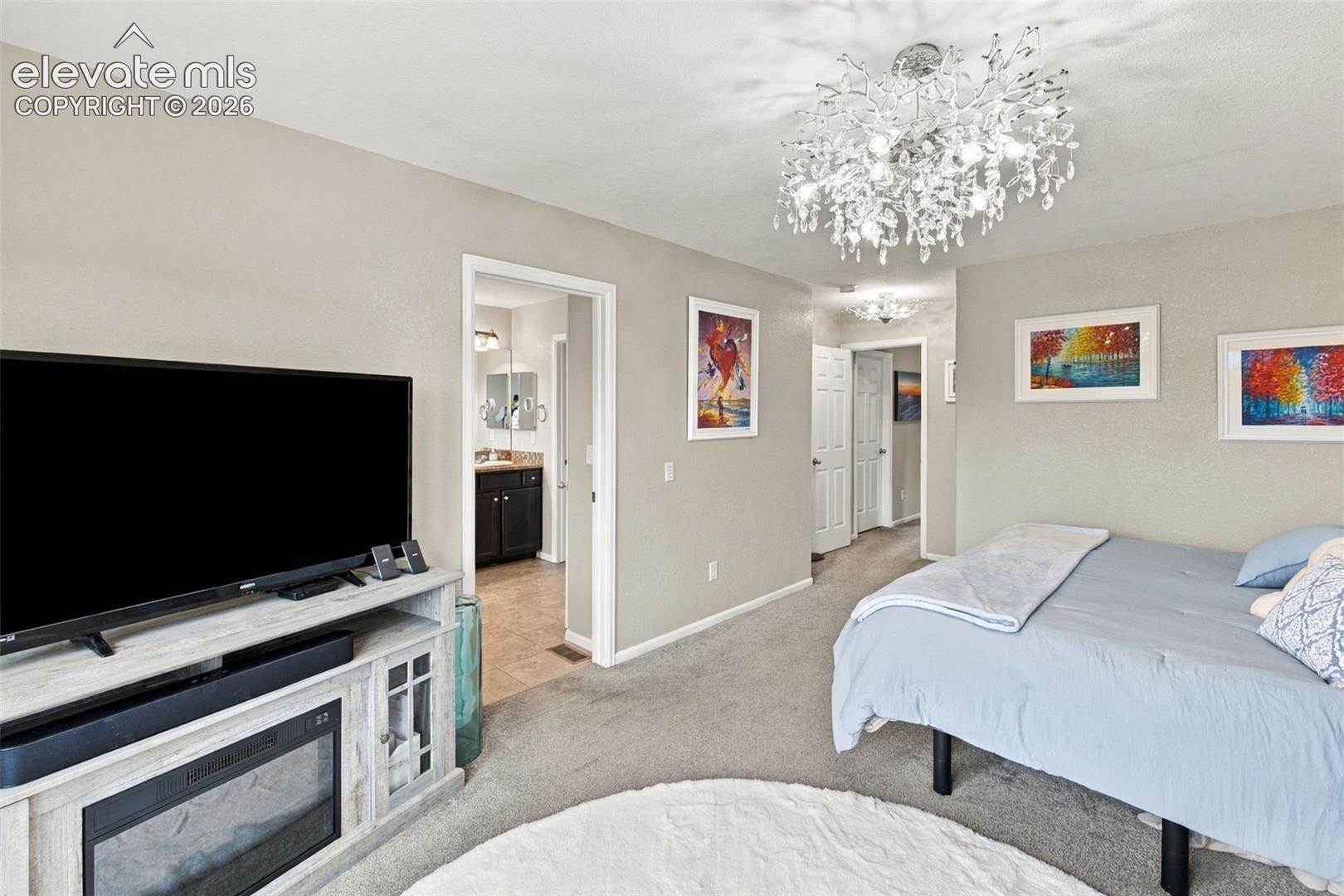 Multi-paneled chandelier with crystalline accents, neutral wall tones, and interior six-panel doors