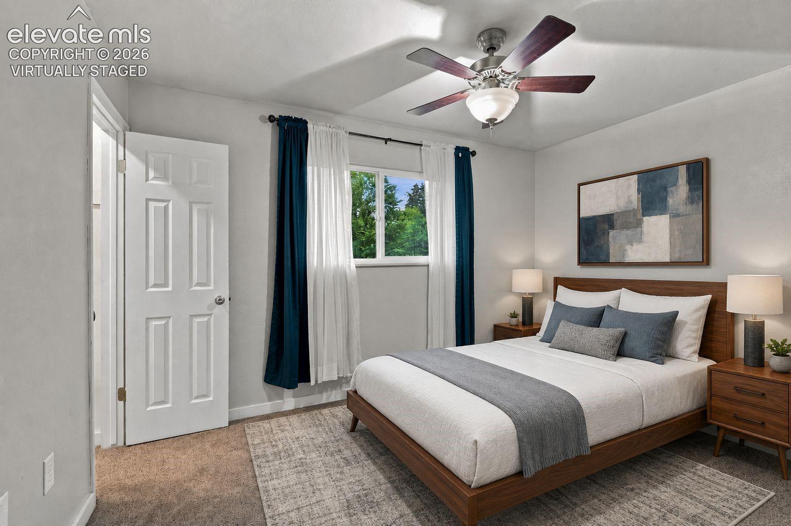 Spacious primary bedroom featuring walk-in closet, carpet flooring, a ceiling fan with integrated lighting, and large windows with dual-layer window treatments *virtually staged
