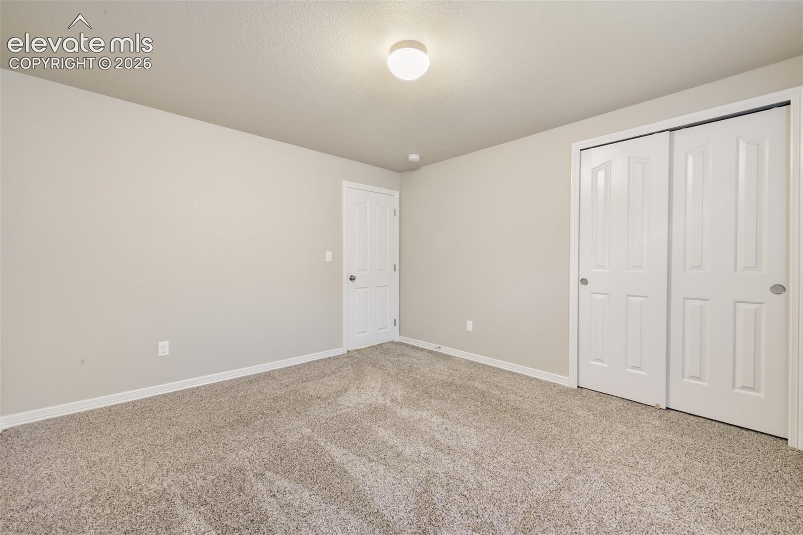 Neutral-toned walls complement the textured carpeting