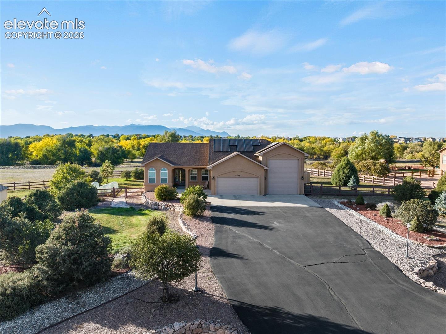 Drone view of the front, low maintenance front landscaping, RV garage, Pikes Peak in the background