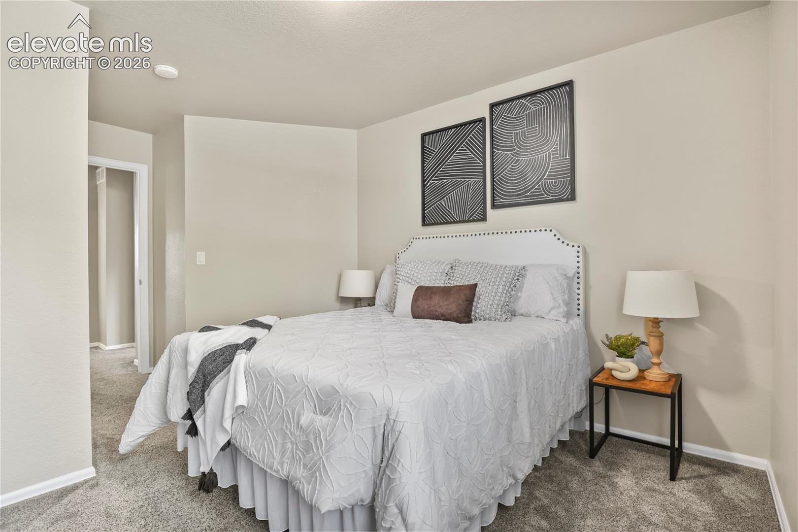 Neutral wall tones, plush wall-to-wall carpeting, and crisp white door casing